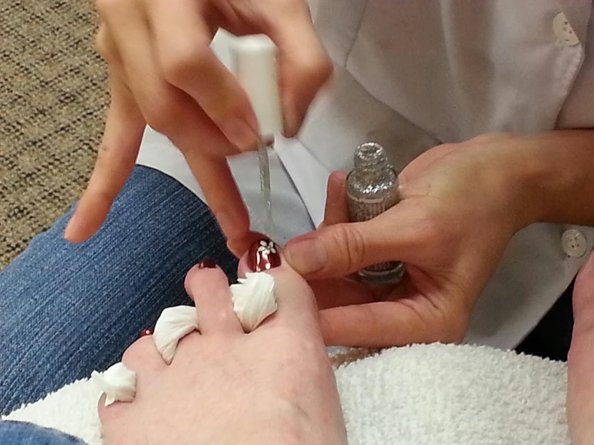 Nail tech applying polish during a manicure